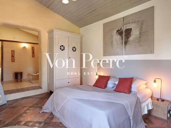 Chambre d'une maison de village rénovée avec lit double et décoration contemporaine.