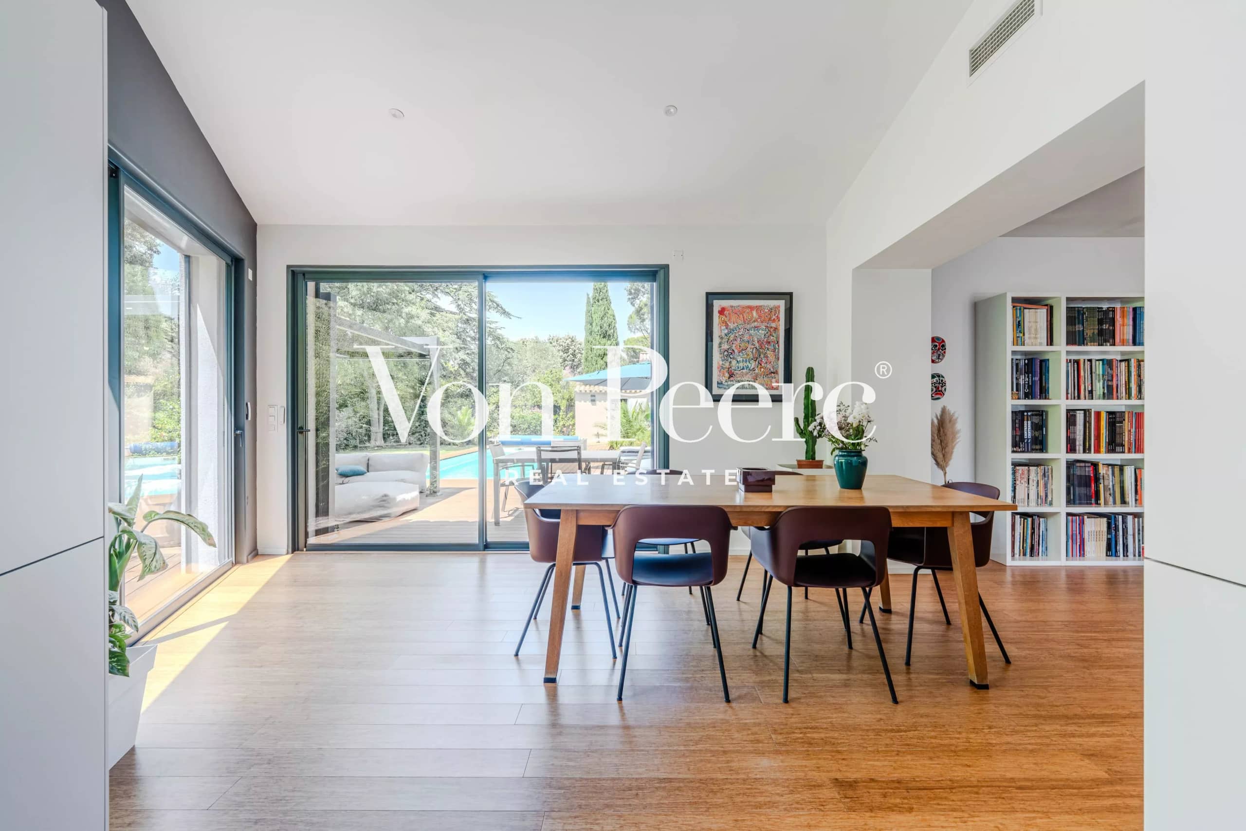 Intérieur d'une villa moderne avec salle à manger et vue sur le jardin.