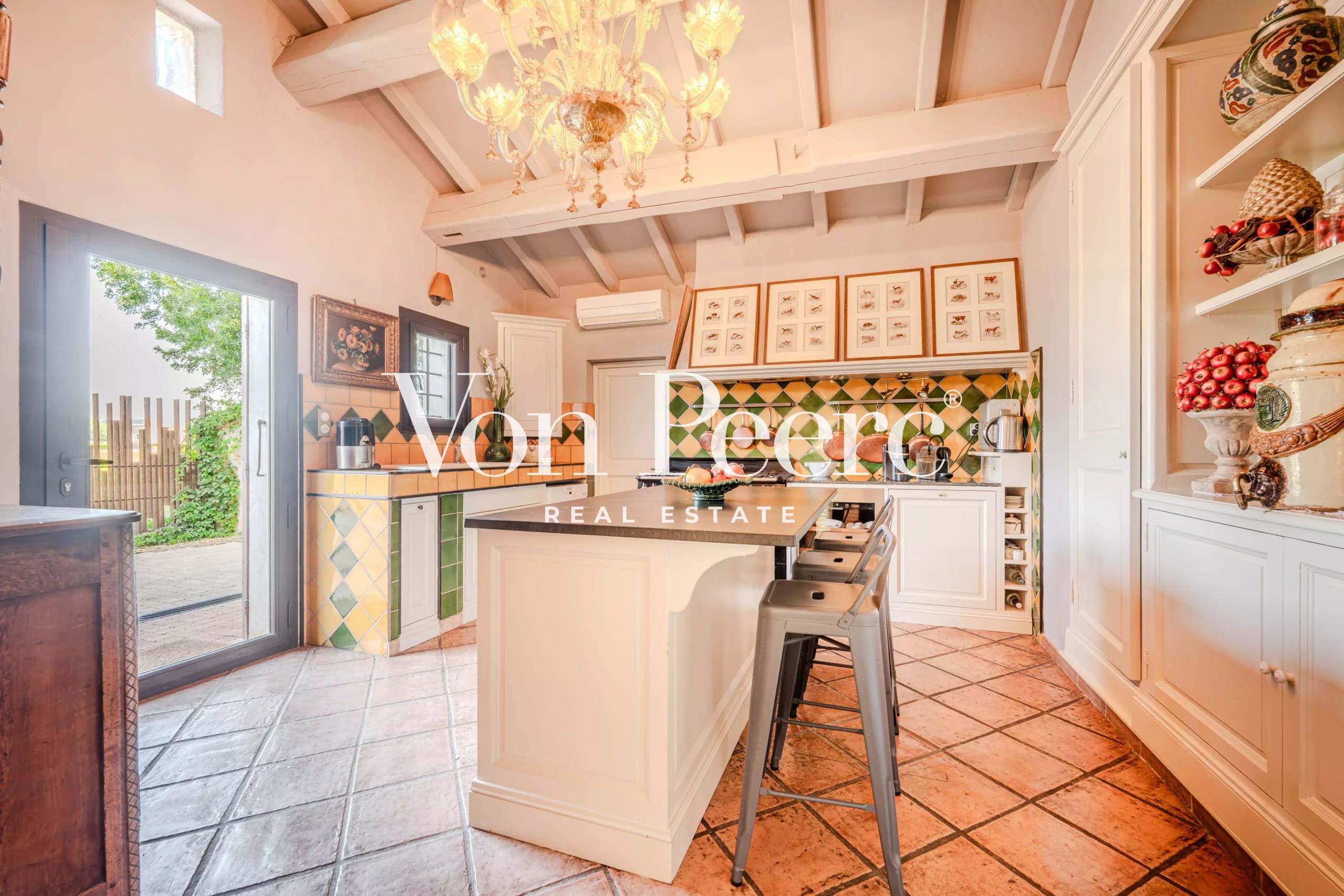 Cuisine d'un mas provençal rénové, avec des éléments de décoration typiques et un éclairage élégant.