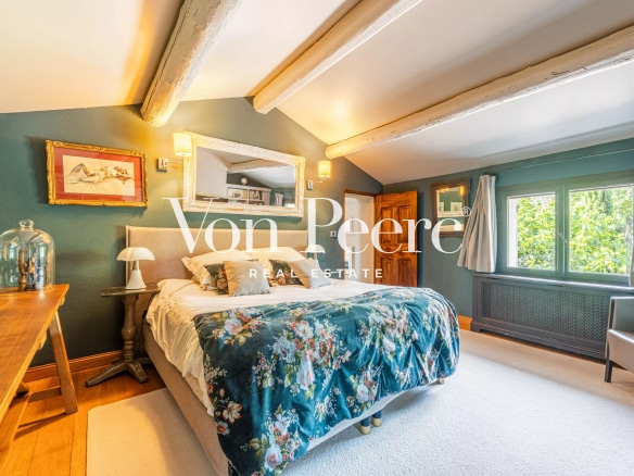 Chambre d'un mas provençal rénové avec lit et décoration florale.