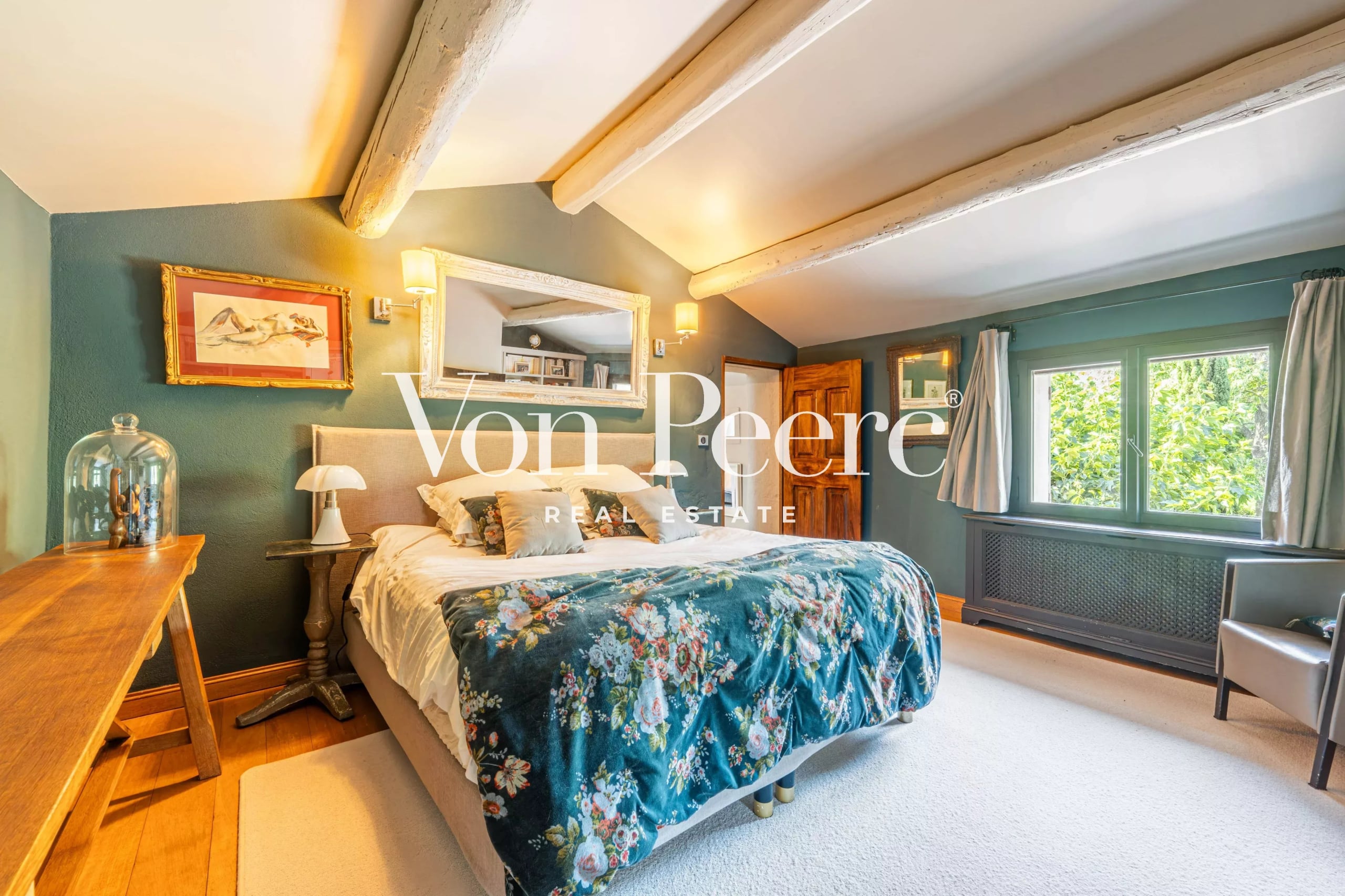 Chambre d'un mas provençal rénové avec lit et décoration florale.