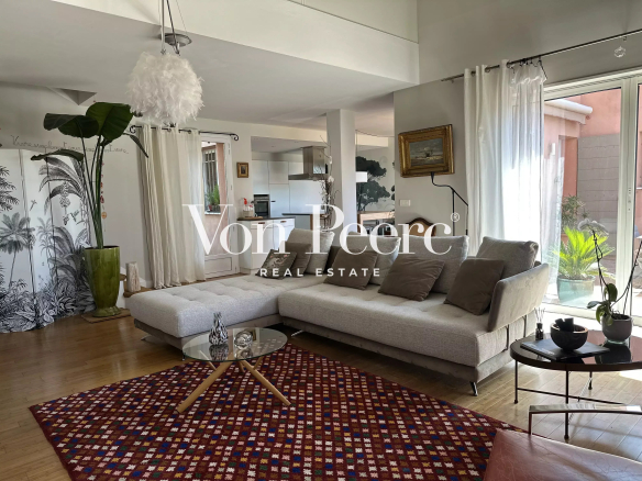 Intérieur d'une maison moderne avec un salon lumineux, un canapé et des éléments décoratifs.