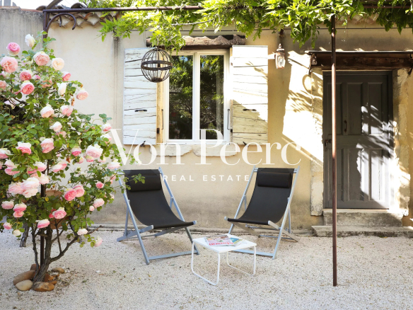 Terrasse d'une maison de caractère avec chaises longues et rosier, Saint-Laurent-des-Arbres.