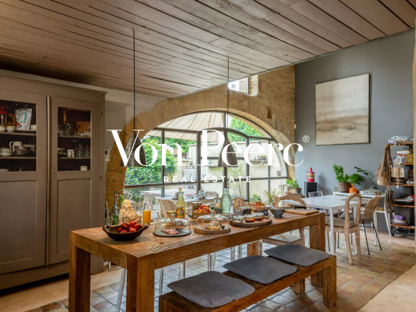 Intérieur d'une maison de caractère avec table à manger, décoration provençale et lumière naturelle.