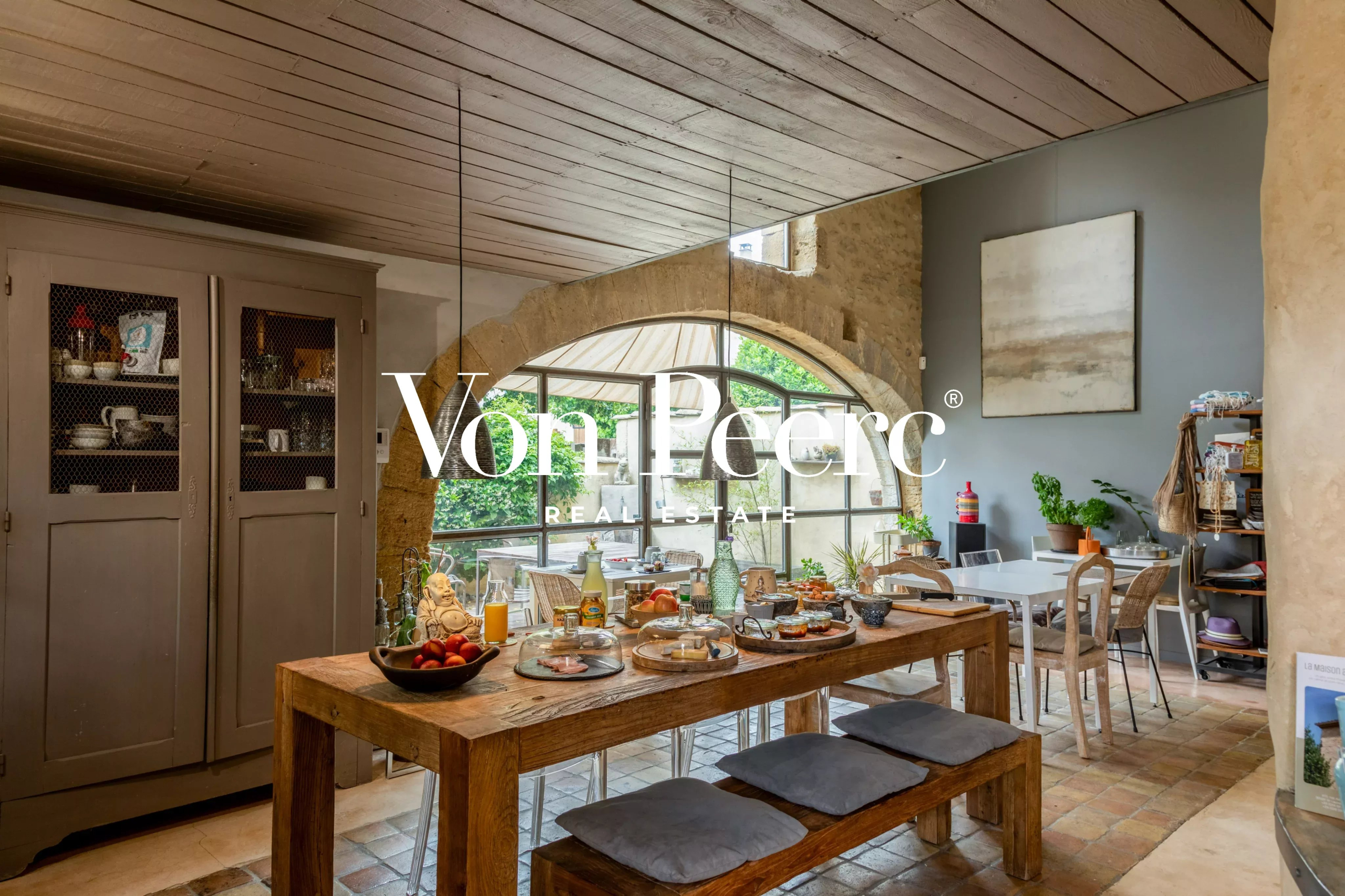 Intérieur d'une maison de caractère avec table à manger, décoration provençale et lumière naturelle.