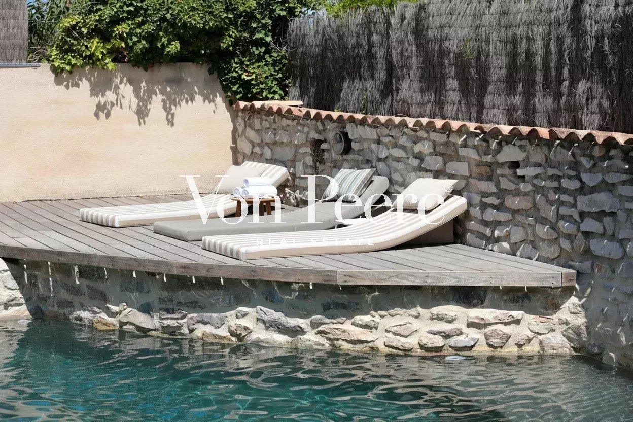 Terrasse en bois avec chaises longues au bord d'une piscine.