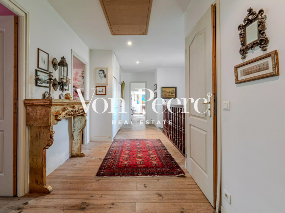 Intérieur d'une maison provençale avec un couloir décoré et un tapis rouge.