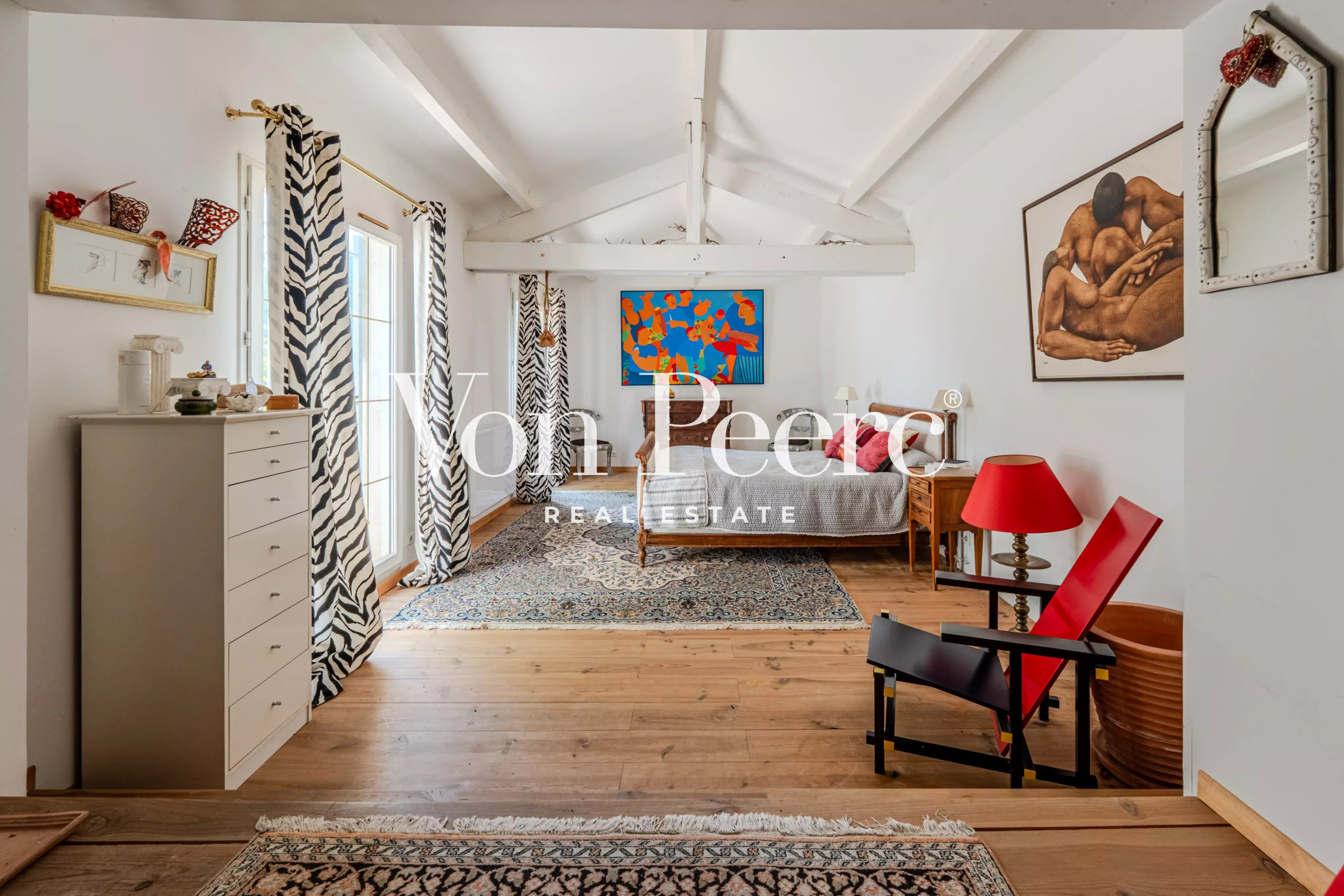 Intérieur d'une chambre lumineuse avec décoration artistique et mobilier en bois.