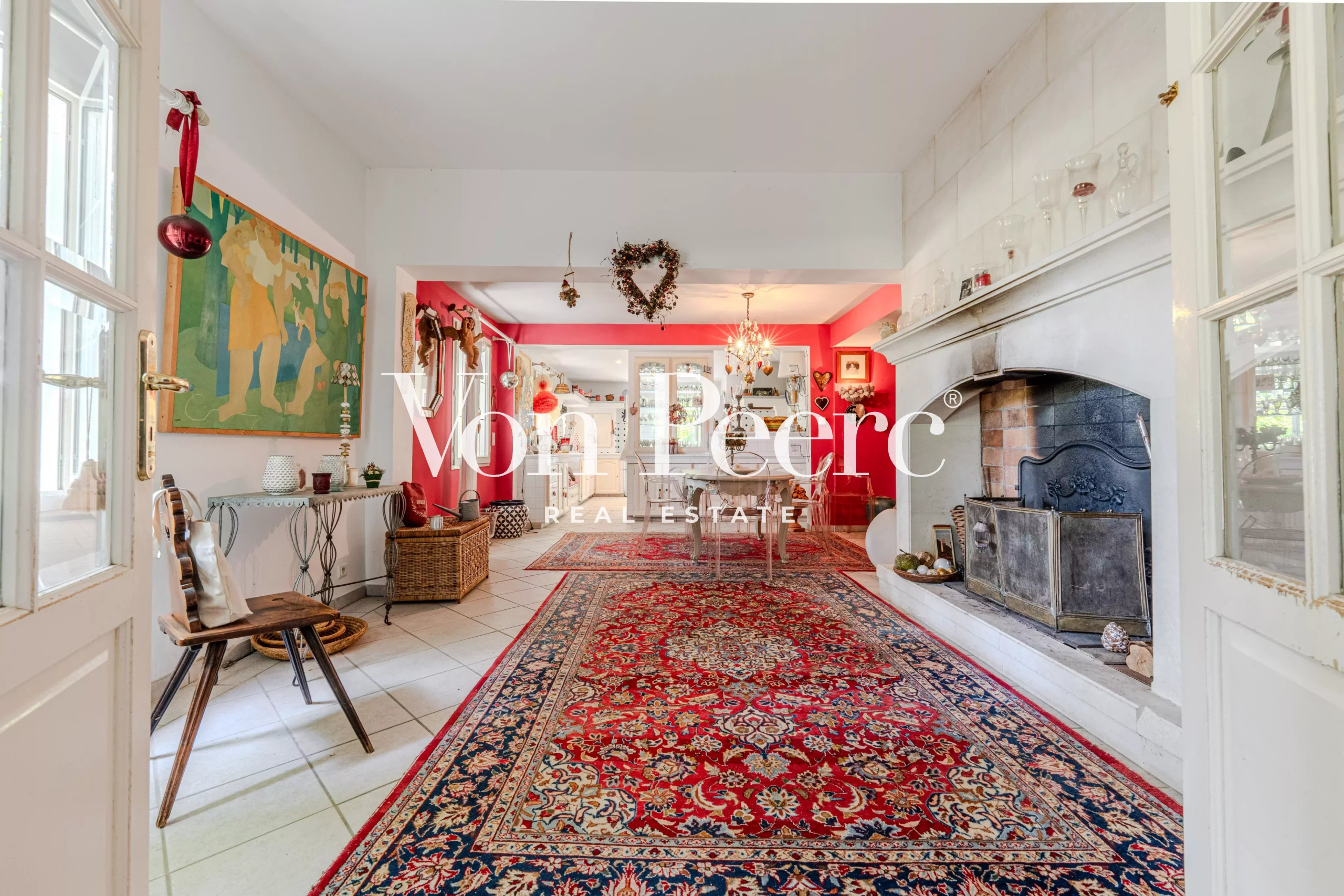Intérieur d'une maison provençale avec cheminée et tapis, décorée avec goût.