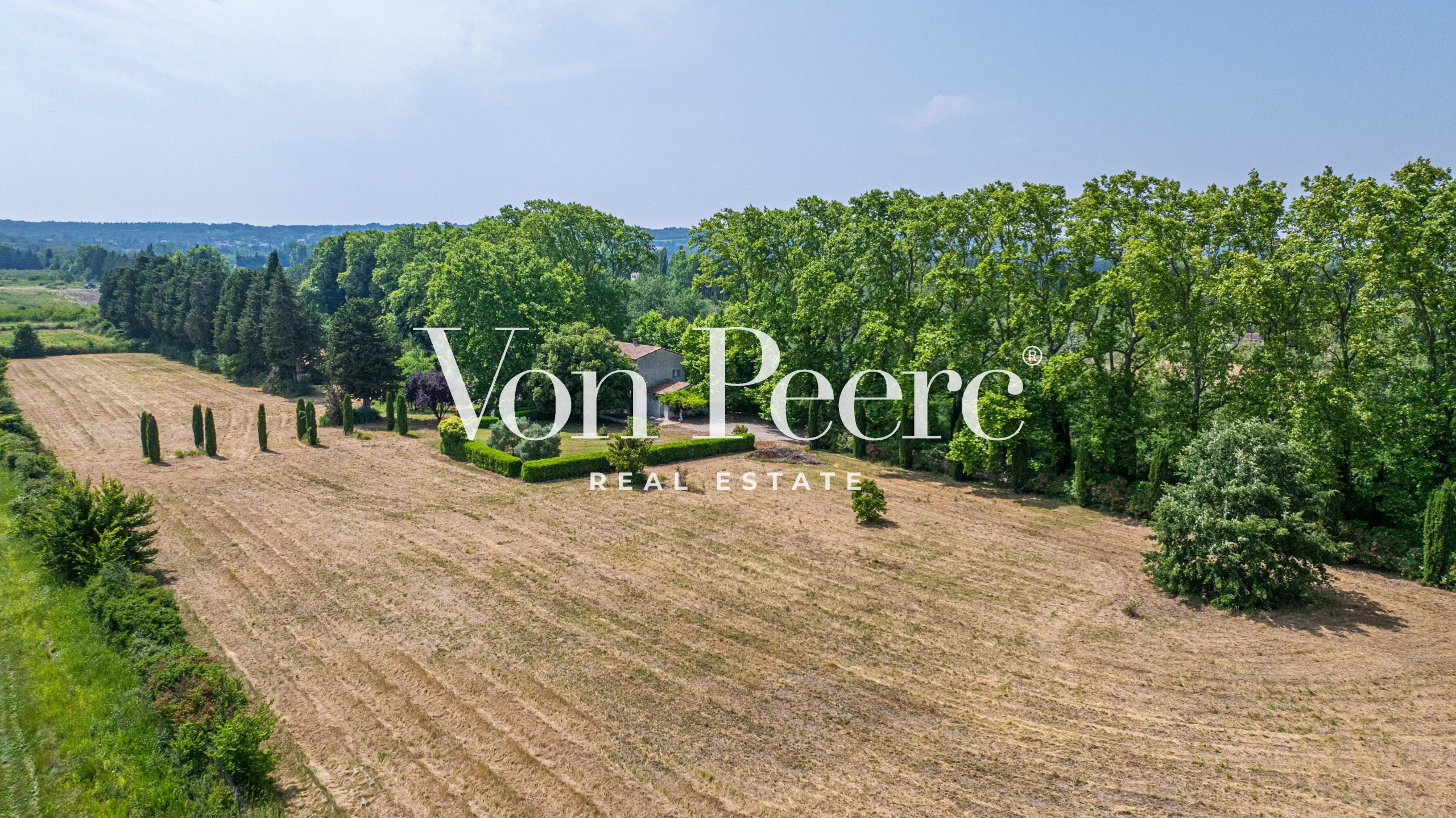 Vue aérienne d'une propriété avec un mas provençal entouré de verdure et de champs à Caumont-sur-Durance.