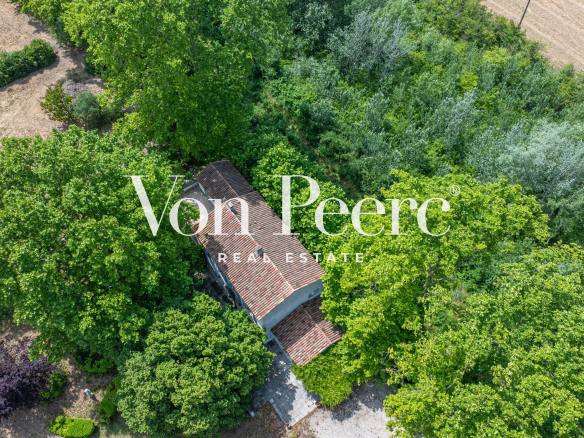 Vue aérienne d'un mas provençal entouré d'arbres et de verdure à Caumont-sur-Durance.