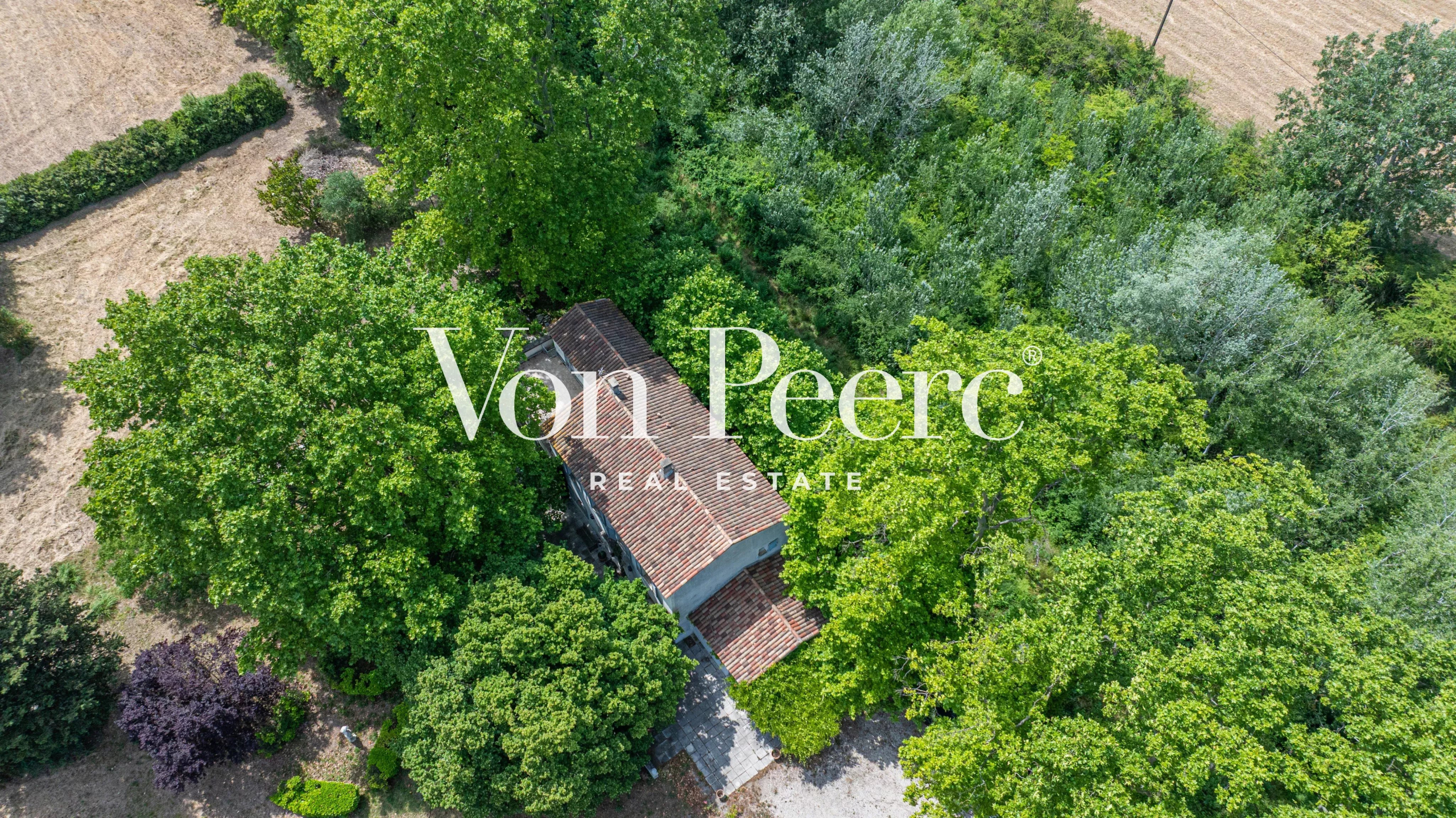 Vue aérienne d'un mas provençal entouré d'arbres et de verdure à Caumont-sur-Durance.