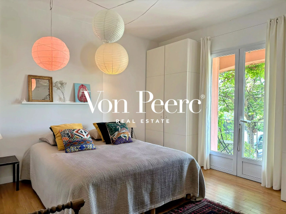 Chambre lumineuse avec lit double, décoration moderne et accès à un balcon.