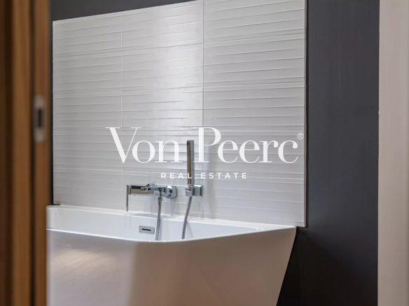 Modern bathroom with designer bathtub and tiled wall