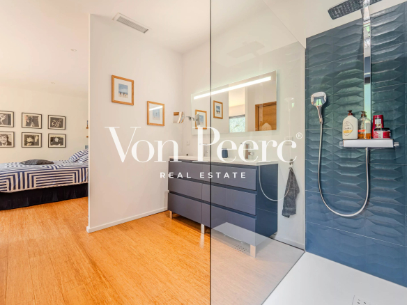 Modern bathroom with shower and bedroom in the background in a villa in Villeneuve-lès-Avignon.