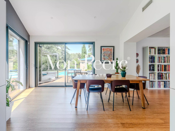 Interior of a modern villa with dining room and garden view.