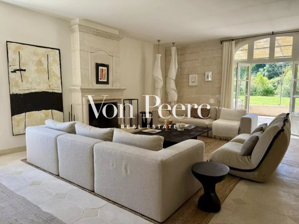 Intérieur d'une maison ancienne rénovée avec un grand séjour lumineux et cheminée.