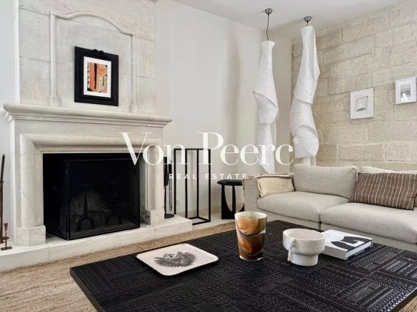 Intérieur d'une maison ancienne rénovée avec cheminée et salon confortable.