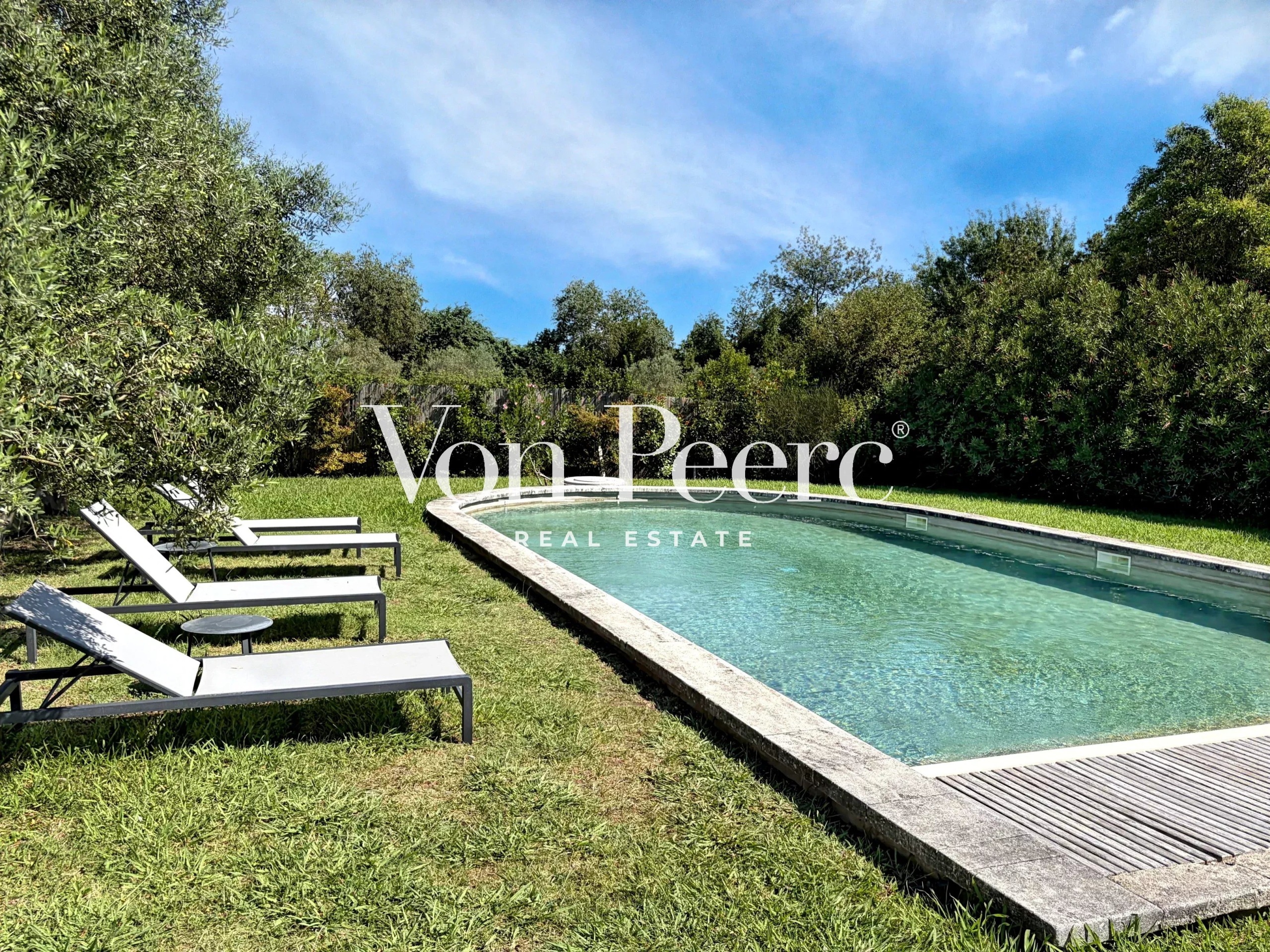 Piscine de maison rénovée à Saint-Rémy-de-Provence Piscine entourée de verdure avec transats, maison rénovée à Saint-Rémy-de-Provence.