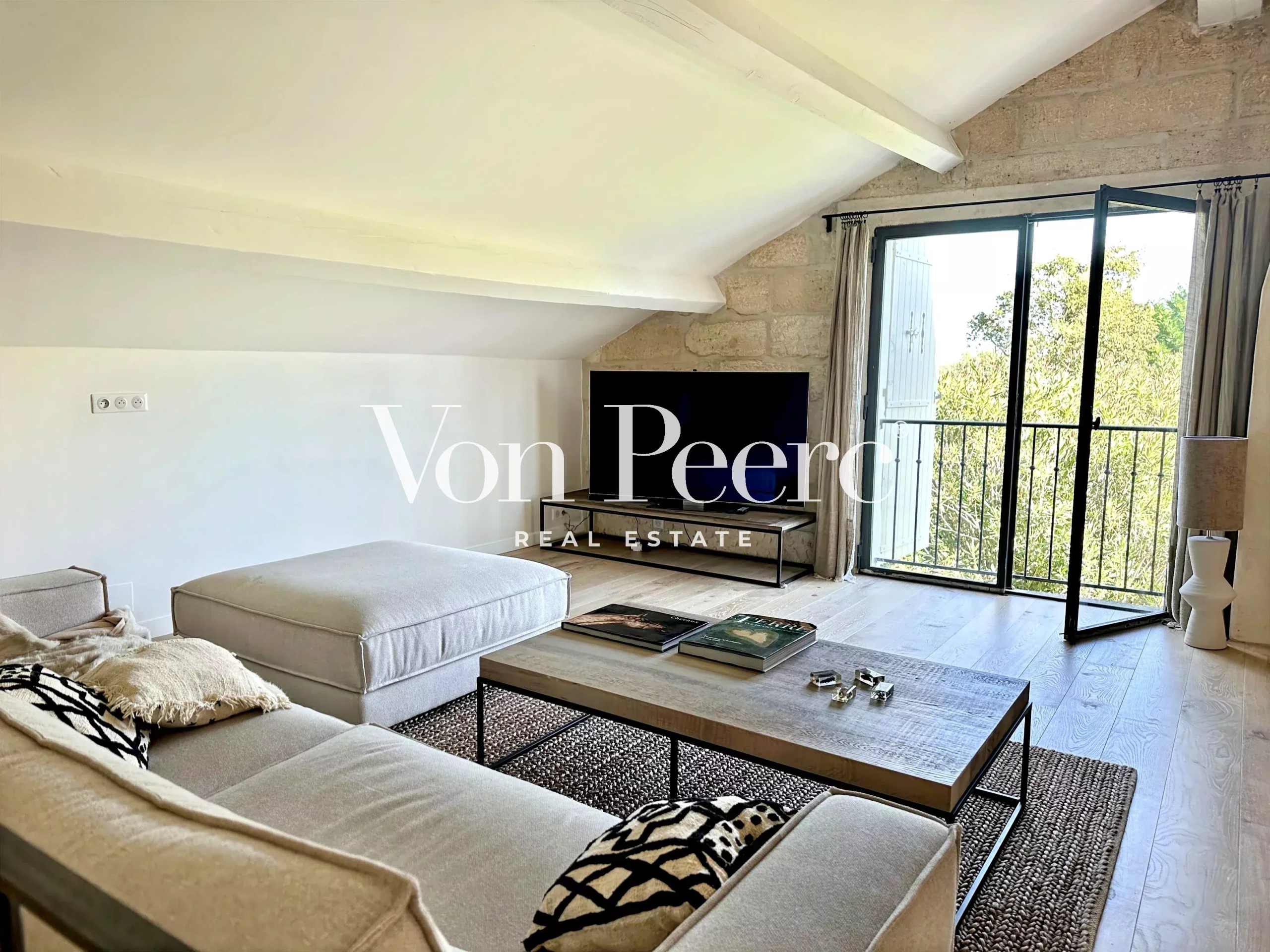 Salon d’une maison rénovée à Saint-Rémy-de-Provence Intérieur d'une maison ancienne rénovée avec un salon lumineux et un balcon à Saint-Rémy-de-Provence.