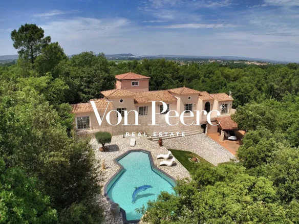 Aerial view of a Provençal villa with swimming pool and garden, surrounded by trees in Saint-Laurent-des-Arbres.