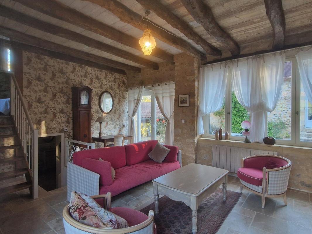 Intérieur d’une maison en pierre Intérieur d'une maison en pierre avec salon confortable, fenêtres lumineuses et mobilier classique.