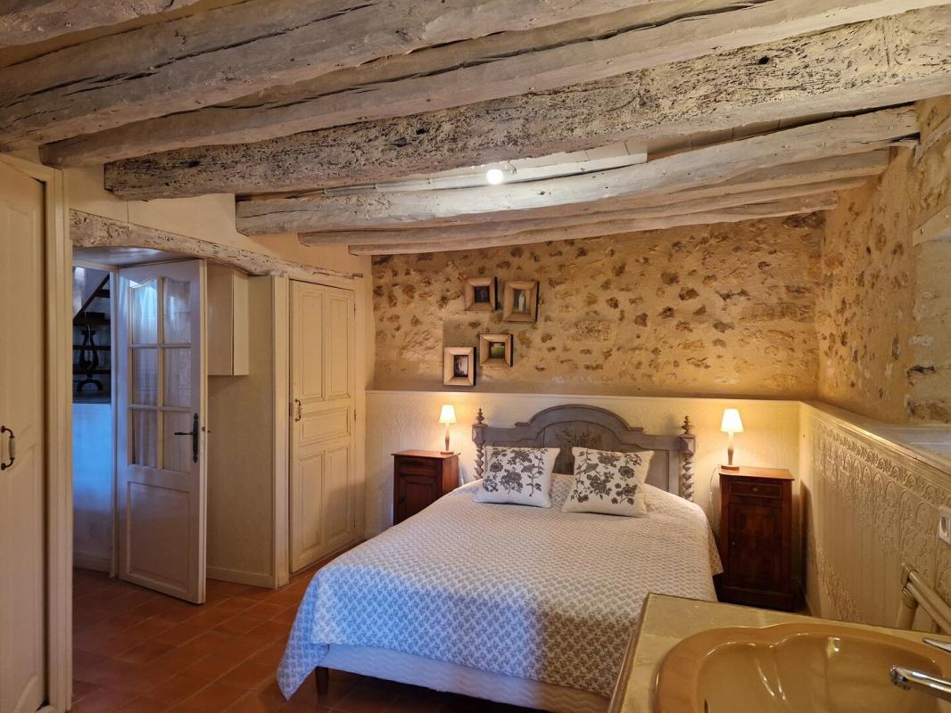 Chambre dans une propriété en pierres Chambre d'une propriété en pierres avec lit double et murs en pierre apparente.