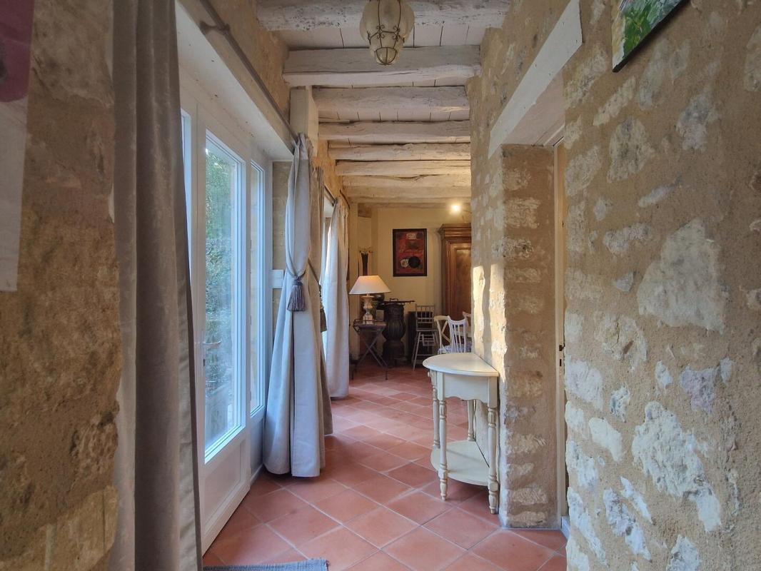 Intérieur d’une propriété en pierre Intérieur d'une maison en pierre avec un couloir lumineux et des murs en pierre apparente.