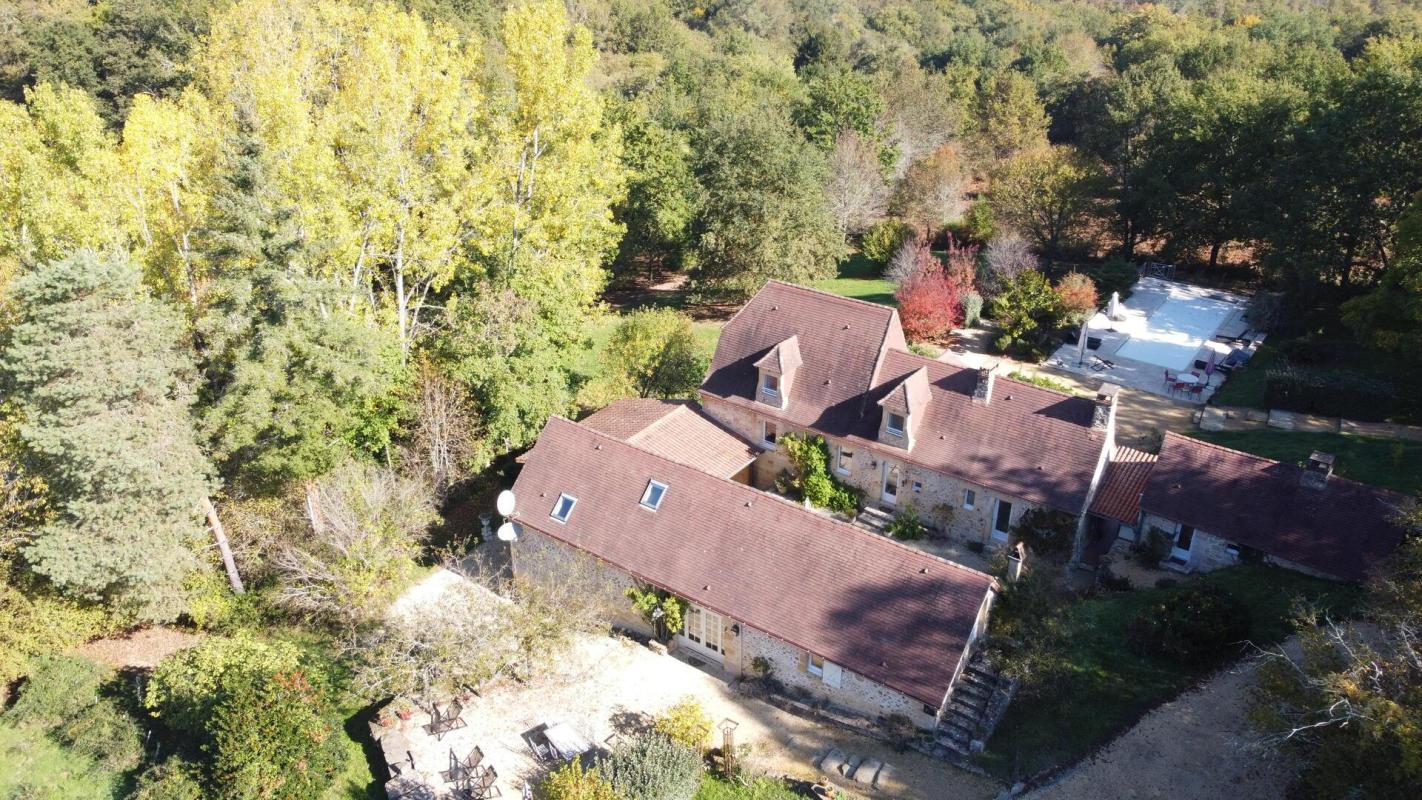 Propriété de charme à Les Eyzies Vue aérienne d'une propriété en pierres avec piscine et terrain arboré à Les Eyzies.