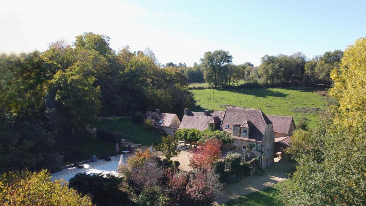 Propriété de charme à Les Eyzies Vue aérienne d'une propriété en pierres avec piscine et terrain arboré à Les Eyzies