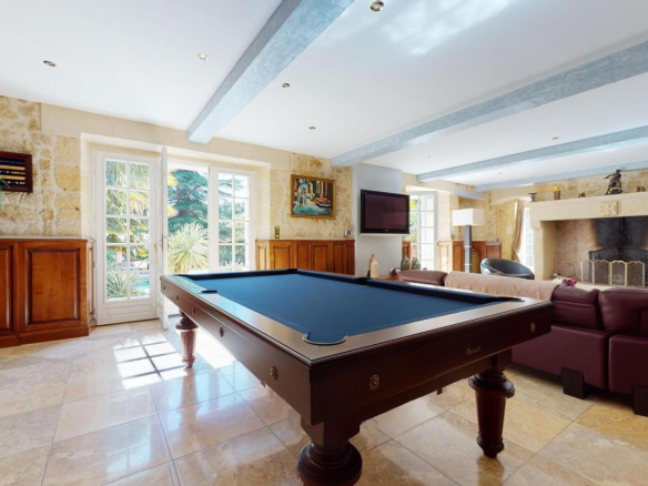 Intérieur d'une belle demeure en pierres avec billard et salon à Sarlat-la-Canéda.