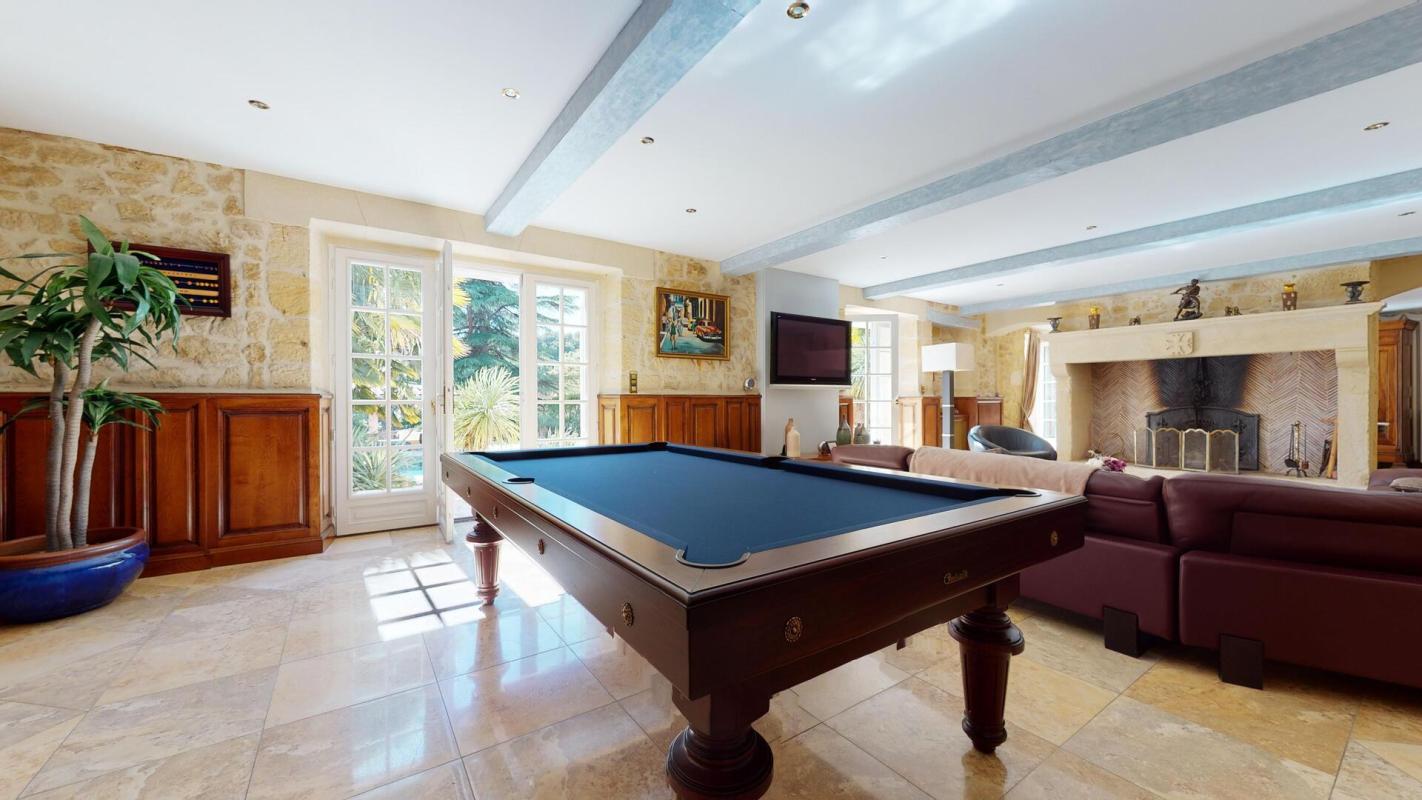 Intérieur d'une belle demeure en pierres avec billard et salon à Sarlat-la-Canéda.