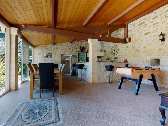 Intérieur d'une belle demeure en pierres avec un espace de vie lumineux et un baby-foot.