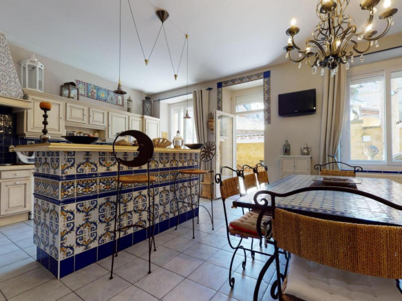 Cuisine spacieuse avec carrelage décoratif et mobilier en bois à Sarlat-la-Canéda