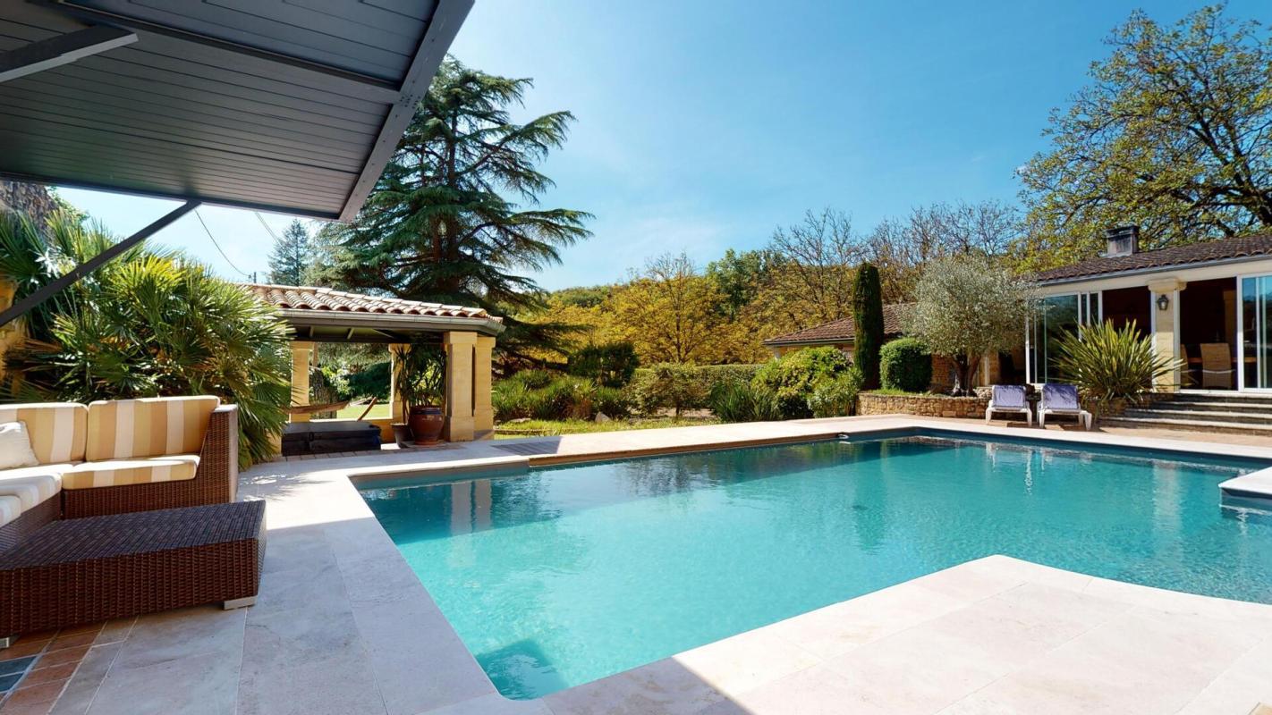 Piscine et terrasse d'une belle demeure en pierres à Sarlat-la-Canéda, Périgord Noir.