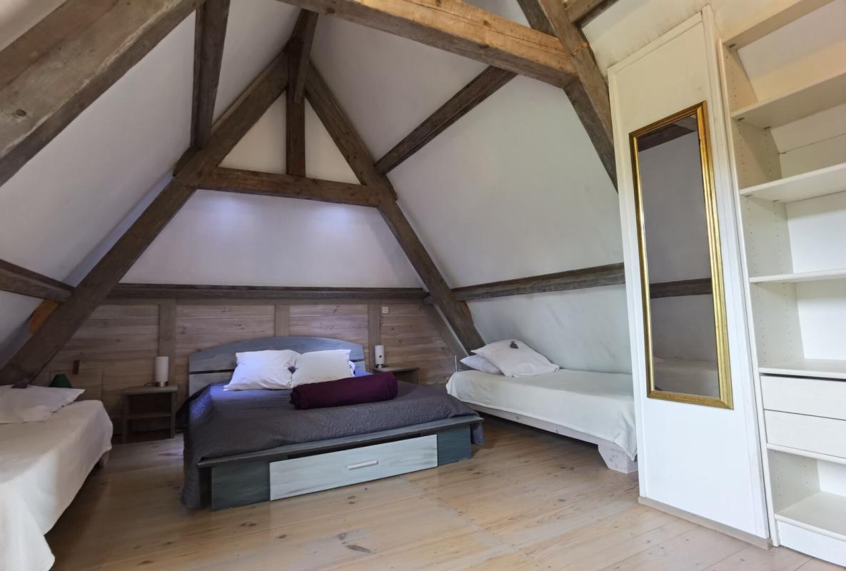 Attic room Attic room with exposed beams and single beds in Excideuil.