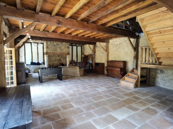 Interior of a stone barn with exposed beams and open space.