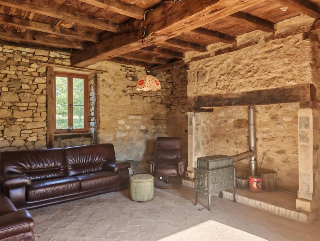 Interior of a farmhouse in Excideuil Interior of a stone farmhouse with a living room, stone walls and a stove.
