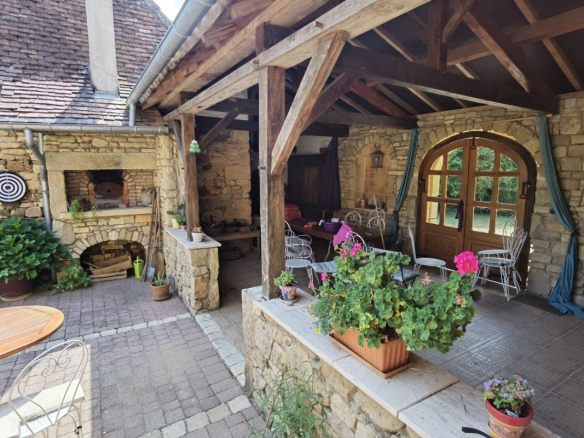 Stone terrace of a farmhouse with furniture and plants, Excideuil.