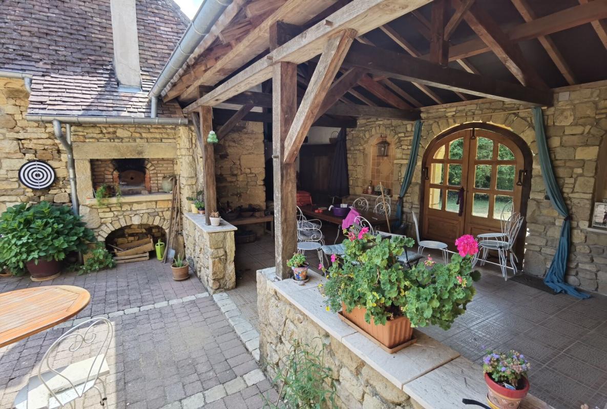 Terrace of a farmhouse in Excideuil Stone terrace of a farmhouse with furniture and plants, Excideuil.