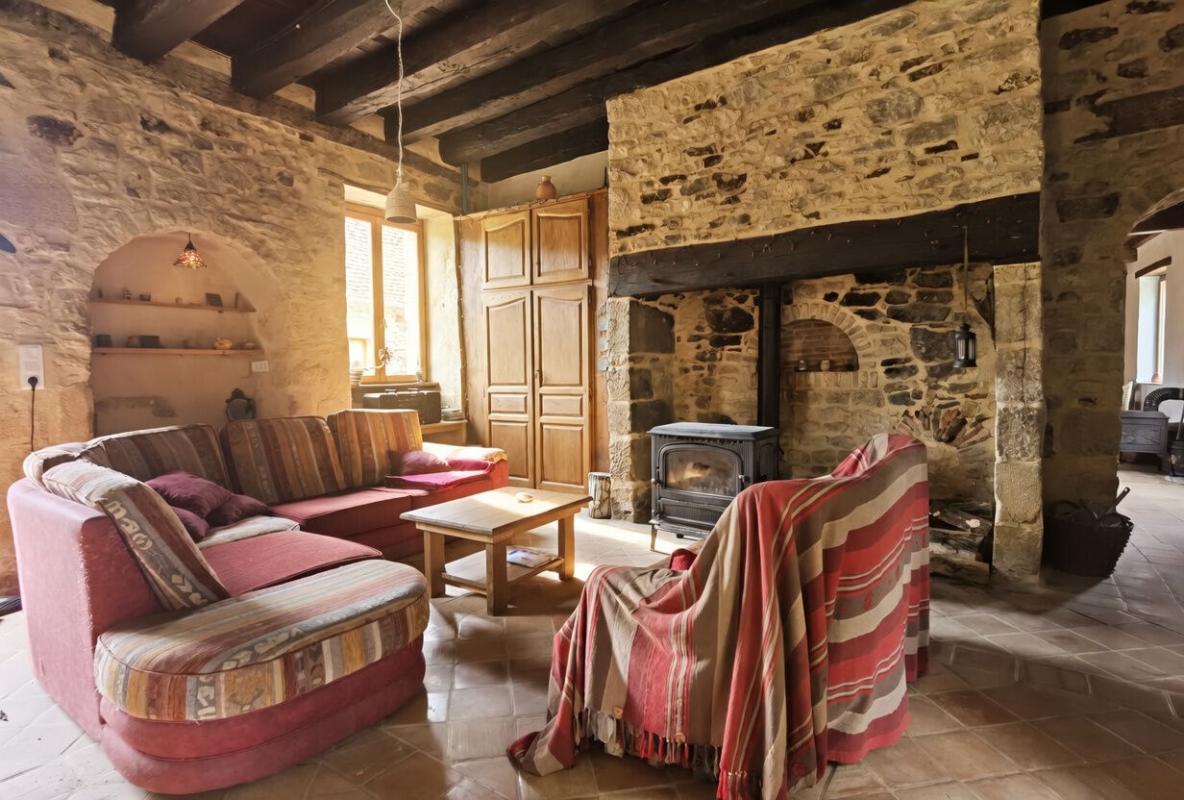 Living room of a farmhouse in Excideuil Interior of a stone farmhouse with a cozy living room and a fireplace.