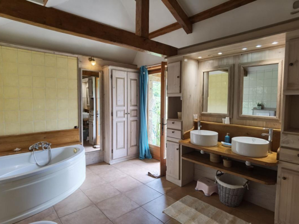 Spacious bathroom with bathtub and double sink in a farmhouse in Excideuil.
