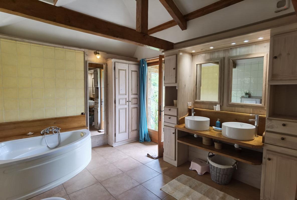 Bathroom in a farmhouse in Excideuil Spacious bathroom with bathtub and double sink in a farmhouse in Excideuil.