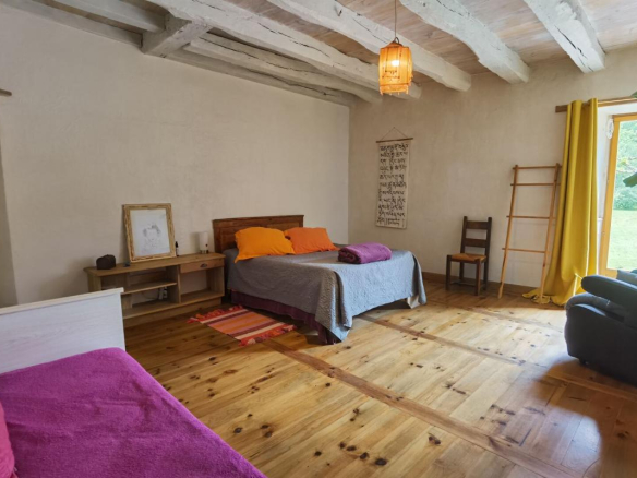 Spacious room with beds, wooden furniture and natural light.