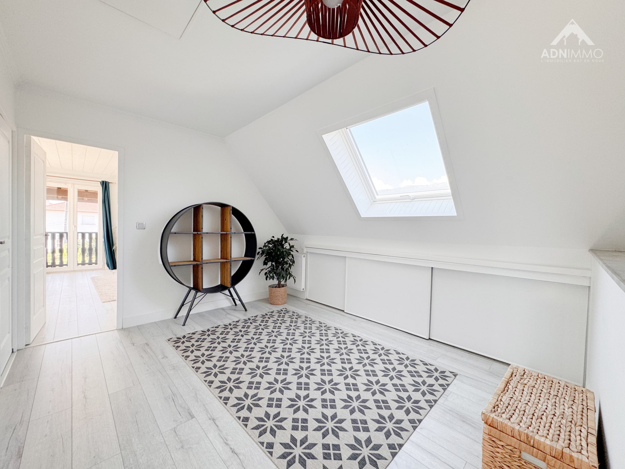 Interior of a house in Saint-Genis-Pouilly Interior of a renovated house with a skylight, a round piece of furniture and a decorative rug.