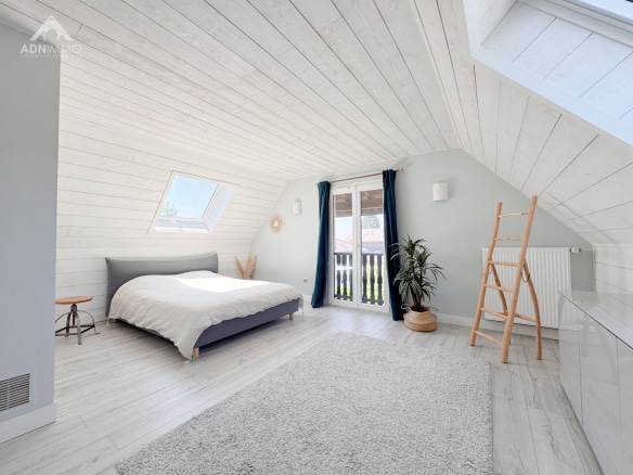 Spacious room with a sloping ceiling, double bed and access to a balcony.
