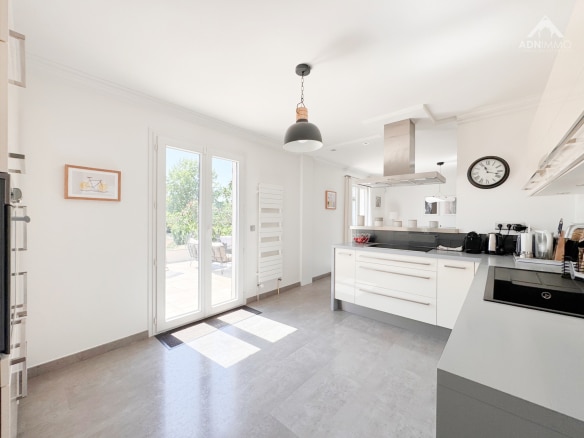 Modern and bright kitchen in a renovated house in Saint-Genis-Pouilly, with access to the outside.