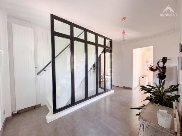 Interior of a modern house with a staircase and glass walls.