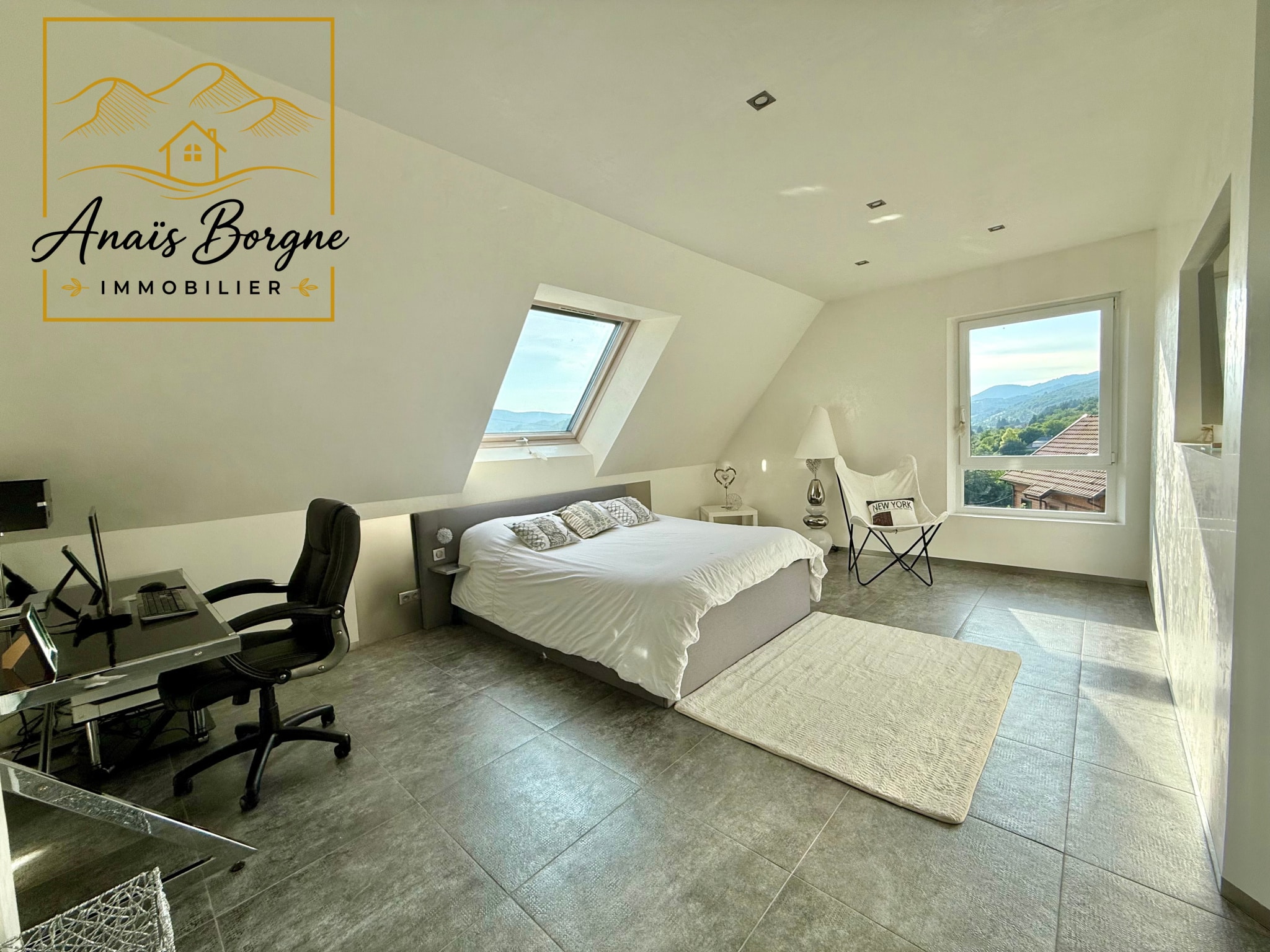 Chambre spacieuse avec vue sur la vallée, décor moderne et lumineux.