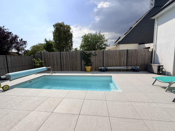Piscine et terrasse en carrelage d'une maison contemporaine à Vannes.